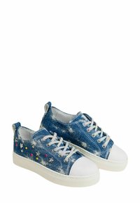 Sneaker in denim blu con punte in gomma bianca, tessuto testurizzato, dettagli metallici e elementi decorativi multicolori sui lati.