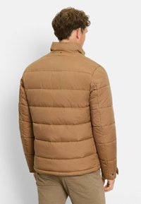 Braune Puffjacke mit Stehkragen und horizontalen Nähten. Verfügt über einen verdeckten Reißverschluss und Seitentaschen, gefertigt aus einem glatten, leichten Material.
