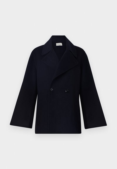 Cappotto doppiopetto navy con ampi revers e maniche oversize, realizzato in tessuto testurizzato. Presenta due bottoni neri e un design minimalista.
