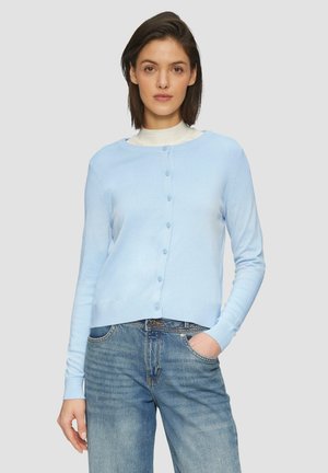 Hellblauer Cardigan mit Knopfverschluss, Rundhalsausschnitt und langen Ärmeln. Aus weichem Material gefertigt, über einem weißen Oberteil und einer Jeans getragen.