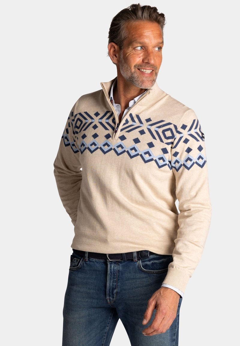Beige pullover trui met een kwart rits, met een geometrisch blauw patroon op de borst, gemaakt van een gladde, zachte stof.