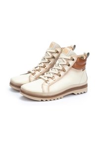 Beige and brown high-top boots with a smooth leather upper, textured lace, and contrasting rubber outsole featuring a jagged tread pattern.