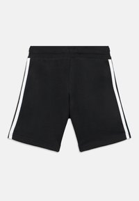 Μαύρο σορτς από βαμβακερό μείγμα, με λευκές ρίγες στα πλαϊνά, ελαστική μέση και απλό σχέδιο. Χωρίς τσέπες ή επιπλέον λεπτομέρειες.