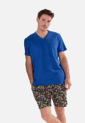 Blå bomulds V-hals t-shirt med brystlomme, parret med sorte shorts med et flerfarvet sommerfuglemønster.