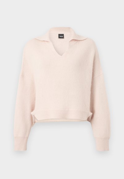 Pull rose clair en tricot avec col en V et col, épaules tombantes, ourlet et poignets côtelés. Fabriqué à partir d'un matériau doux et texturé.