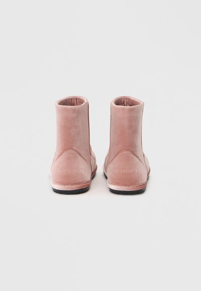 Stivaletti in velluto rosa soft con una texture liscia. Presentano un tacco basso e una suola in gomma nera. Marchio visibile sul retro.
