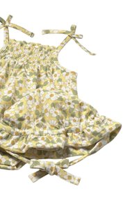 Top amarillo con estampado floral de margaritas blancas y acentos verdes. Presenta un corpiño fruncido y tirantes ajustables. Dobladillo con volantes.