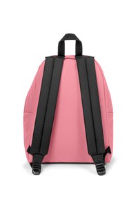 Růžový batoh se zaobleným tvarem, černými popruhy a horním uchopovacím madlem. Vyroben z hladkého materiálu s bočními kapsami pro dodatečné úložné prostory.