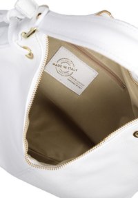 Witte leren handtas met een ritsluiting, voorzien van een beige interieur en een label met de tekst "Made in Italy" en "Genuine Leather."