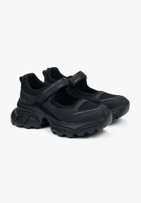 Czarne buty sportowe z siateczkową cholewką, dwiema regulowanymi klamrami, grubymi gumowymi podeszwami i teksturowanymi detalami zapewniającymi przyczepność. Nowoczesny design z wyściółką.