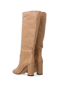 Helle Lederstiefel bis zum Knie mit glatter Textur, abgerundeter Spitze und klobigen, quadratischen Absätzen. Das gefaltete Design am oberen Ende sorgt für visuelles Interesse.
