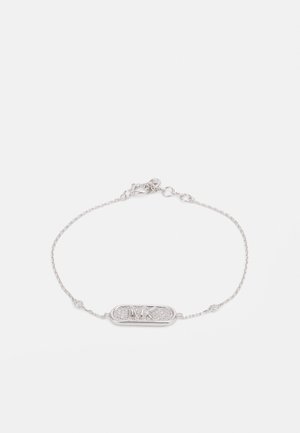 Silver chain bracelet featuring an elongated oval charm with embossed initials and a textured surface, accented with small decorative elements.