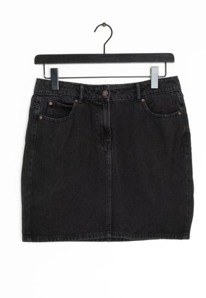 Mini-jupe en denim noir avec poches avant et passants de ceinture, suspendue à un cintre noir sur un fond blanc.