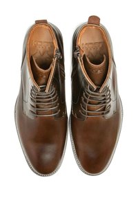 Des chaussures en cuir marron avec une finition brillante, présentant un design à lacets et une fermeture éclair sur le côté. Texture lisse et forme de bout arrondi.