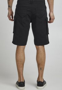 Shorts cargo noirs en tissu résistant, avec poches latérales, taille normale et ourlet fini.