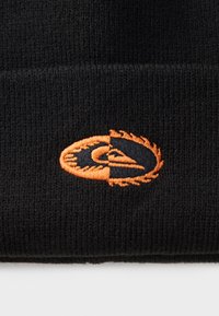 Black knit beanie featuring an orange embroidered logo with a circular design and flame-like accents. Soft texture with a thick ribbed pattern.