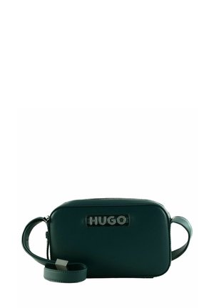 Sac en cuir vert à bandoulière, de forme rectangulaire, avec fermeture zippée et un logo "HUGO" noir bien en évidence à l'avant.