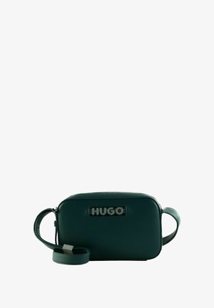Sac en cuir vert à bandoulière, de forme rectangulaire, avec fermeture zippée et un logo "HUGO" noir bien en évidence à l'avant.