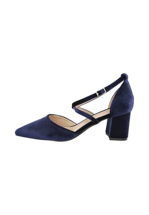 Zapato de mujer de ante azul marino con punta afilada, tacón ancho y doble correa al tobillo con hebilla plateada sobre fondo blanco.