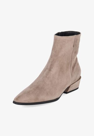 Bottine beige en daim avec bout pointu, talon épais et semelle noire, vue de biais.