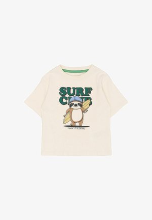 Cremefarbenes T-Shirt mit kurzen Ärmeln, das ein Cartoon-Faultier mit blauer Mütze zeigt, das ein Surfbrett hält, sowie den grünen Schriftzug "SURF CLUB".
