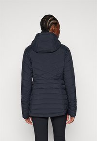 Mørkeblå pufferjakke med hette, med quiltet chevron-design, lange ermer og en lett innsnittet midje for en tettsittende look.