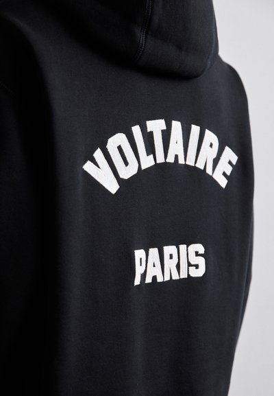 Hoodie noir avec le texte brodé blanc "VOLTAIRE" en arc au-dessus de "PARIS" au dos, fabriqué en tissu doux avec une finition texturée.