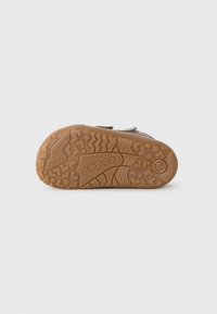 Sole of a small children's shoe with textured rubber tread, brand name "Froddo Barefoot," and size 23 marked on the heel.