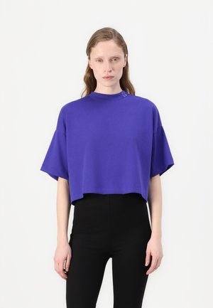 Purple cropped t-shirt with a high neckline and short sleeves. Features subtle logo detail near the neckline, made from a soft fabric.