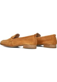 Tan suède loafers met een ronde neus, minimale stitching en een kleine, gestapelde houten hak. Glad textuur en eenvoudig ontwerp.