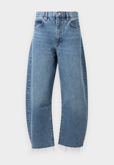 Kõrge vöökohaga, lõdvalt liibuvad sinised denimpüksid, millel on kulunud serv. Omab viit taskut, vöökootte ja kontrastset õmblust.