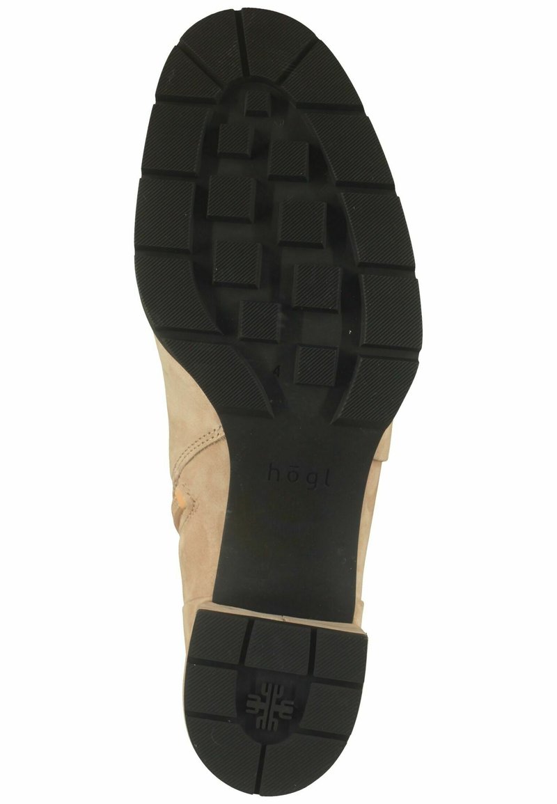 Beige Wildlederschuh mit einer schwarzen Gummisohle, die über ein strukturiertes Grip-Muster und ein geprägtes Markenlogo verfügt, entworfen für Langlebigkeit und Komfort.