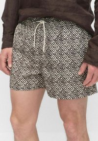 Patronen zwemshorts met een ruitdesign in bruin en crème, voorzien van een elastische tailleband en een trekkoordsluiting.