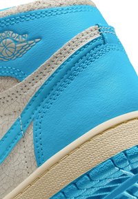 Sneaker in pelle blu con accenti grigi testurizzati, dotato di suola testurizzata e cuciture visibili. Logo impresso sulla parte superiore.
