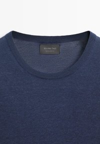 Maglione blu navy con collo rotondo, dalla trama finemente lavorata a maglia e un'etichetta nera con la scritta "Massimo Dutti Made in Italy" all'interno del colletto.