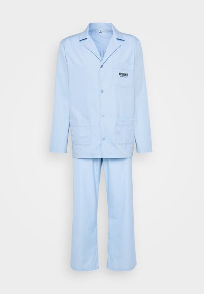 Lys blå todelt pysjamassett med en knappåpen jakke med brystlomme og løstsittende bukser. Laget av myk stoff.