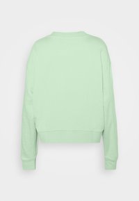 Sweat-shirt court vert menthe avec manches longues, encolure arrondie et poignets côtelés. Confectionné dans un tissu doux à la texture lisse.