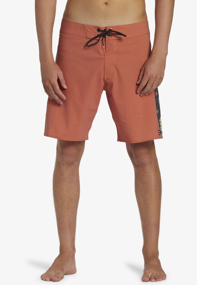 Shorts de bain pour homme en corail, en tissu léger, avec un cordon noir. Présente un motif floral sur le côté. Longueur mi-cuisse.