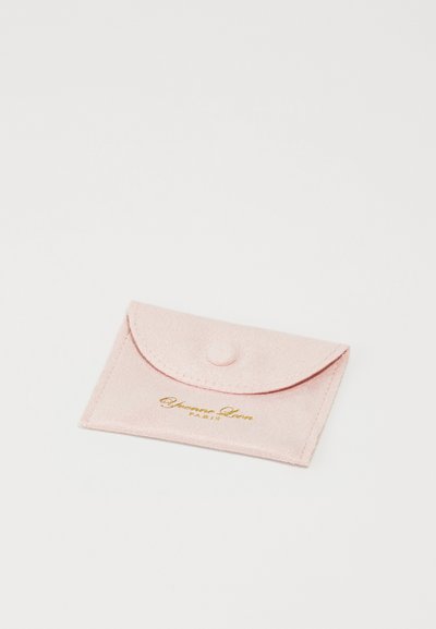 Pink suede cardholder with a rounded flap, button closure, and gold embossed text reading "Yves Saint Laurent, PARIS." Soft texture.