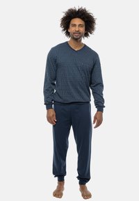 Marineblauwe pyjama set met een gestreepte lange mouwen top met een V-hals en bijpassende broek met elastische boorden, gemaakt van zachte stof.