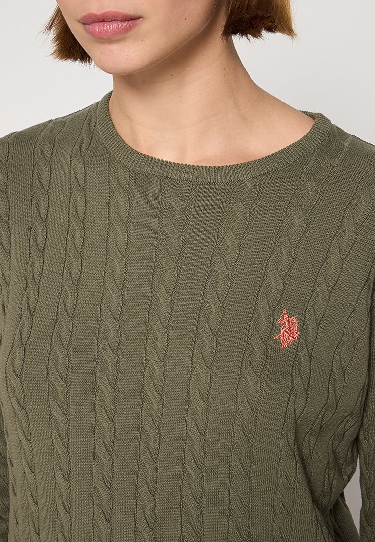 Olivgrüner kabelgestrickter Pullover mit rundem Halsausschnitt und gerippten Kanten. Mit einem kleinen gestickten Logo in hellem Koralle. Strukturierter Stoff.