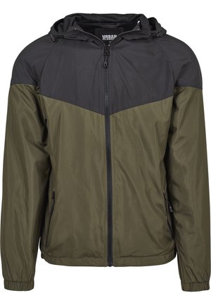 Veste coupe-vent à capuche pour homme avec fermeture éclair frontale, corps vert olive et empiècement et épaules noirs, avec poches latérales zippées.