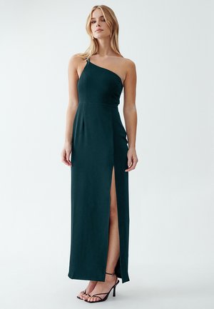 Abito maxi verde scuro a spalla unica con uno spacco laterale. Realizzato in tessuto morbido, presenta un corpetto aderente e una silhouette lunga e dritta.