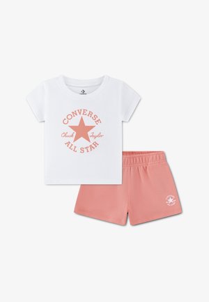Converse bērnu apģērbs, kurā ir balta T-krekls ar persiku krāsas zvaigžņu logotipu un saskaņotas persiku krāsas elastīgas šorti ar logotipa detaļām. Mīksts kokvilnas maisījums.