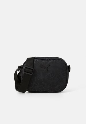 Black sling bag with a padded design, featuring subtle Puma branding and a textured pattern. Adjustable strap for versatile carrying options.