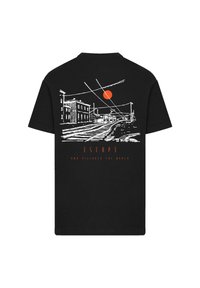 Black cotton t-shirt featuring a white line-drawing of a street scene with an orange sun, text reading "ESCAP3 AND DISCOVER THE WORLD."