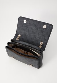 Bolso de mano texturizado negro con herrajes plateados, que presenta una solapa plegable, compartimentos interiores y un detalle de cadena. El interior es de un color más claro.