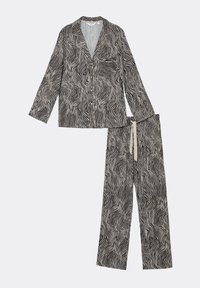 Schlafanzugset in Schwarz und Creme, bestehend aus einem knöpfbaren Oberteil mit einer Tasche und langen Ärmeln sowie passenden weit geschnittenen Hosen mit einem welligen Muster.