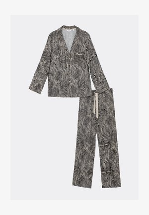 Schlafanzugset in Schwarz und Creme, bestehend aus einem knöpfbaren Oberteil mit einer Tasche und langen Ärmeln sowie passenden weit geschnittenen Hosen mit einem welligen Muster.