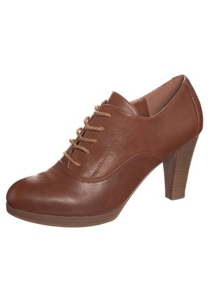 Bruine leren hoge hak schoen met een ronde neus, vetersluiting en een gestructureerde hak. Glad oppervlak met subtiele stiksels.